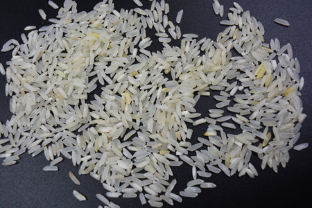 Close up of white rice grains on black background with copy space. Food products, fresh tasty round rice located on black plastic background.の写真素材