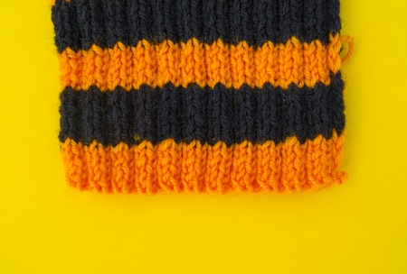 The process of knitting gaiters on a Halloween holiday. Witch costume. Autumn cosiness. Yellow background.の写真素材