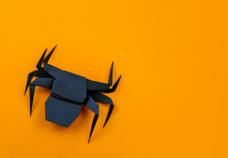 Origami Halloween. Black spider made of paper. Copy spaceの写真素材