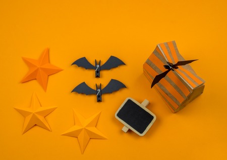 Orange background with collection of Halloween objects overhead view. Black cat, spider, bat, witch, feared party decor. Handwork.の写真素材