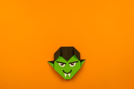 Orange background with collection of Halloween objects origami overhead view. Green monster.Feared party decor. Handwork.の写真素材