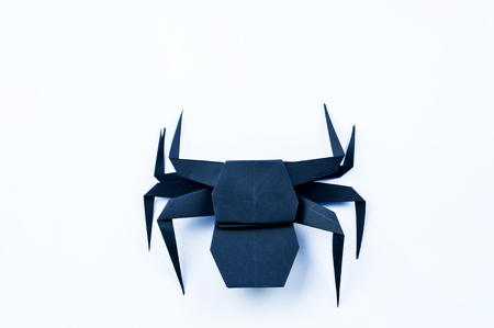 Origami Halloween. Black spider made of paper. Copy spaceの写真素材