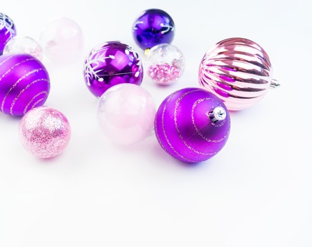 Gentle pink and purple baubles on a white background. Christmas mood. Festive decor. Sequins and glitter for a party.の写真素材