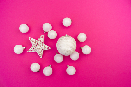 Gentle white baubles on a pink background. Christmas mood. Festive decor. Sequins and glitter for a party.の写真素材