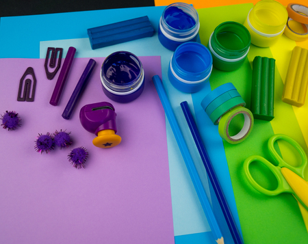 School accessories are laid out in the form of a rainbow. Black background.Happy back to school student. Art and crafts for kids. Child learning rainbow colors, alphabet letters and numbers.の写真素材
