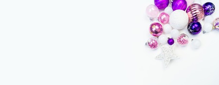 Gentle pink and purple baubles on a white background. Christmas mood. Festive decor. Sequins and glitter for a party.の写真素材