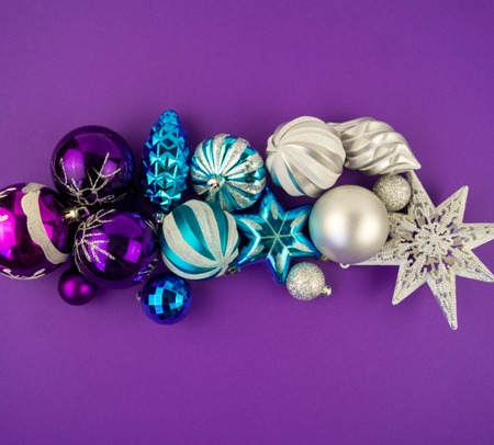 Colorful christmas baubles in white, purple and blue. Brilliant toys for decorating the Christmas tree on a purple background.の写真素材