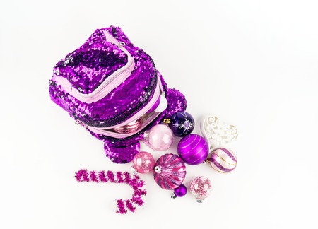 Decorations for the Christmas tree from a backpack on a white background. Purple girls briefcase...