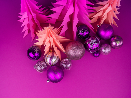 Christmas tree made of pink and purple craft paper. Handicraft. Violet background. Forest origami. Christmas ball baublesの写真素材