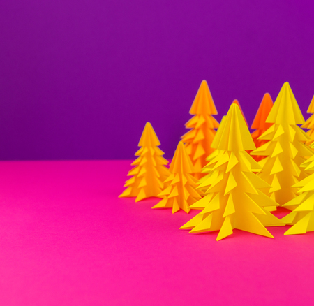 Christmas tree made of yellow craft paper. Handicraft. Violet and pink background. Forestの写真素材