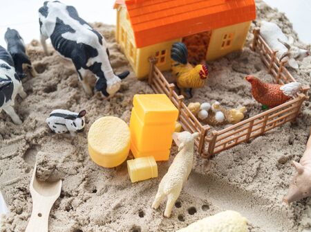 Montessori material. Children's hands play an animal figure. Kinetic sand in the sandbox. Sensory development.の写真素材