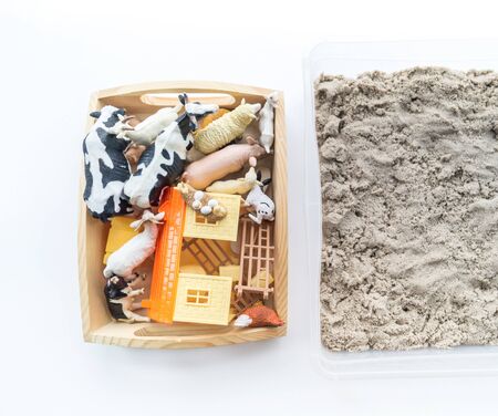 Montessori material. Children's hands play an animal figure. Kinetic sand in the sandbox. Sensory...
