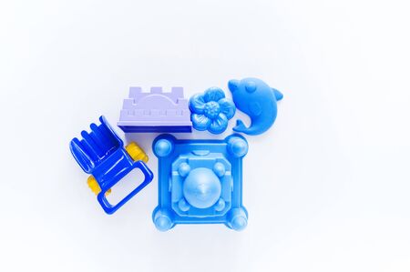 Toys for sand. Children's toy summer sea game. Set of blue plastic mold. White background. Flat lay. Kindergarten playground on outdoorの写真素材