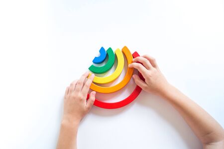 Montessori wood rainbow material. A child plays with a toy with his hands. Child development school kindergarten.の写真素材