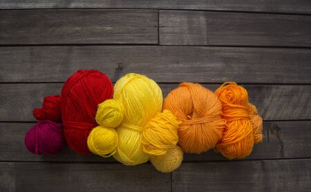 Yarn for knitting rainbow. Wood background. Favorite hobby. Thread in basket