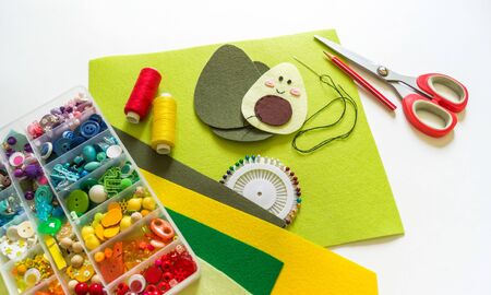 Sewing avocado from felt. Beads and scissors. Children's creativity.の写真素材