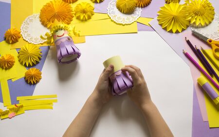 Princess made of paper. White background. Children's hands favorite hobby