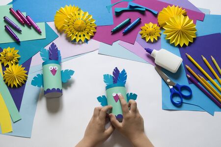 A bird made of paper. Blue bird. Hands of a child. Master Class. craftsmanshipの写真素材