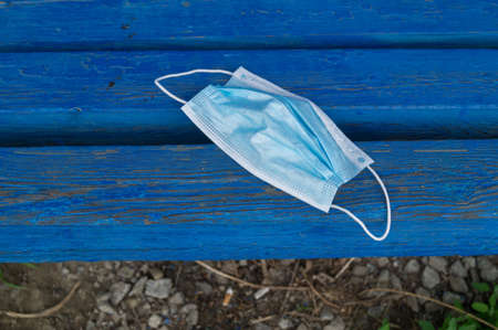 Mask is lying on the bench. Garbage after coronavirus. Zero waste. Ecological lifestyle. Environmental pollution.の写真素材