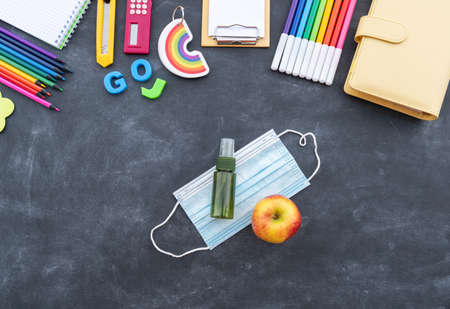 Stationery chalk board. Back to school. Medical mask and hand sanitizer Flat lay Copy Spaceの写真素材