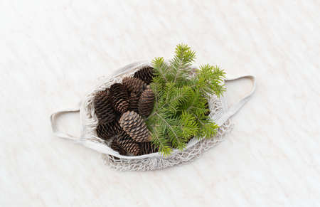 Zero waste Christmas concept. Natural Chirsmas decoration, pine cones and branches in linen bag. Flat lay, top viewの写真素材
