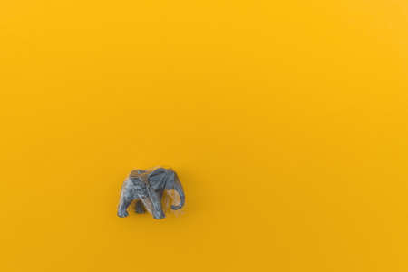 Elephant is entangled in a plastic bag. Plastic animal concept. Yellow background. Environmental pollution problem.の写真素材