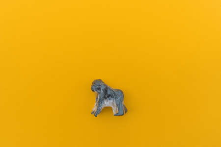 Gorilla is entangled in a plastic bag. Plastic animal concept. Yellow background. Environmental pollution problem.の写真素材