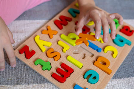Child learns to put words out of letters. English alphabet. Montessori material. Homeschooling...