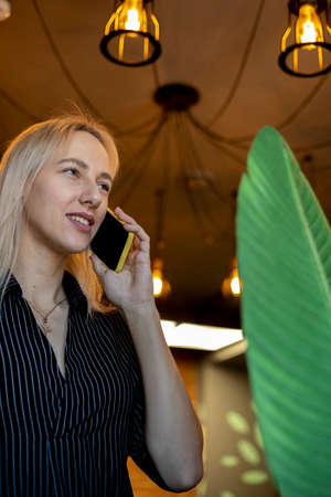 Young woman in white shirt is talking on the phone. Concept use of technology. Lunch break. office...