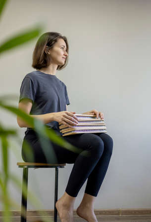 Young girl sits in a chair and holds a sadhu board in her hands. peace of mind. health concept....