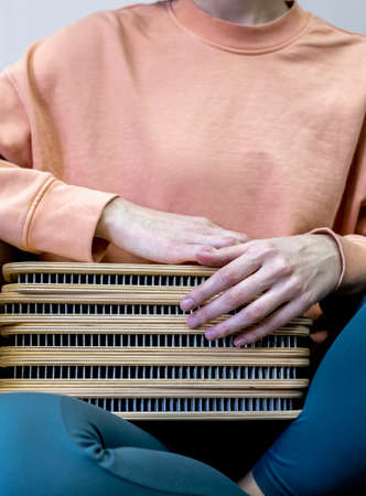 Young girl sits in a chair and holds a sadhu board in her hands. peace of mind. health concept. alternative medicine. mental health.の写真素材