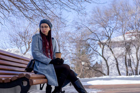 Young Asian girl eco-friendly. Reusable glass for hot drinks. Walk on the street. Pink hair...