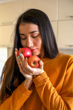 Young Asian woman takes out red apples from a grocery bag. Reusable package. Zero waste. Vegetarian woman. Conscious consumption.の写真素材