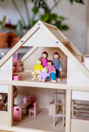 Montessori material. Large wooden doll house with a doll family inside. Home education of the child. gender division people.の写真素材
