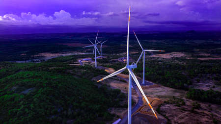 Wind turbines or wind power generators at sunset in the evening. Alternative green ecological power energy generationの写真素材