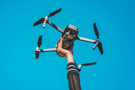 Woman hand holding DJI Mavic 2 Pro drone or quadcopter isolated on the blue sky background. 29.09.2020, Netherlands, Amsterdamのeditorial素材
