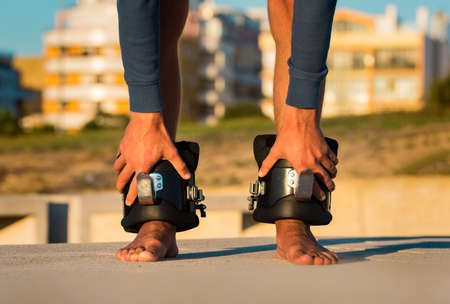 Man in anti gravity or inversion boots for upside down hanging on the horizontal bar. Sports equipment.の写真素材
