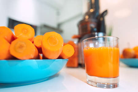 Glass of fresh homemade carrot juice made in juicer machineの写真素材