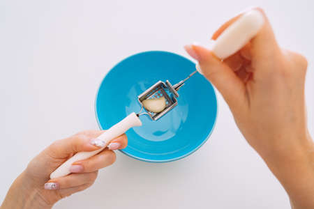 Woman squeezing or crushing fresh garlic with press. Female hands using a garlic press, crusher or mincer.の写真素材