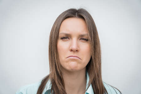 Sad unhappy and disappointed woman face. Young woman frowning face. Facial expression of feeling sadness.の写真素材