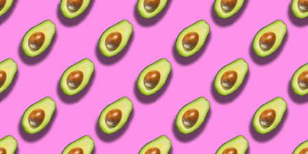 Seamless pattern of fresh ripe green avocado isolated on pink background. Top view. Banner. Flat lay...
