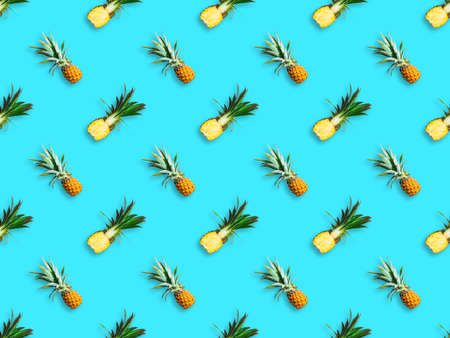 Seamless pattern of ripe pineapples isolated on blue background. Top view. Exotic tropical fruit summer conceptの写真素材