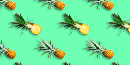 Seamless pattern of ripe pineapples isolated on green background. Top view. Exotic tropical fruit summer concept. Pop artの写真素材