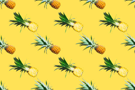 Seamless pattern of ripe pineapples isolated on yellow background. Top view. Exotic tropical fruit summer concept. Pop artの写真素材