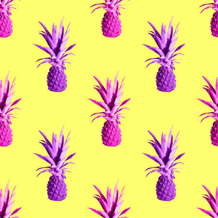 Seamless pattern of pink pineapples isolated on yellow background. Top view. Exotic tropical fruit summer concept. Pop artの写真素材