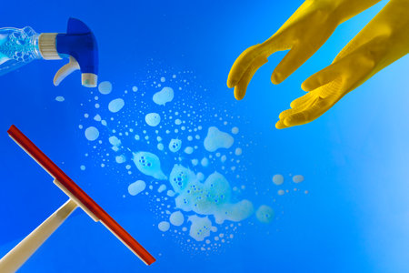 Window cleaning equipment. Cleaning window glass with a squeegee or wiper, yellow gloves and chemicalsの写真素材