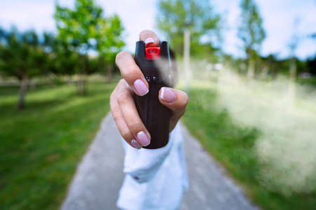 Woman using pepper spray or tear gas for self defence outdoorsの写真素材