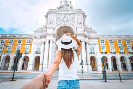 Tourist woman leading man. Follow me. Couple on vacation. Traveling together. Commerce Square with Rua Augusta Arch in in Lisbon, Portugalの写真素材