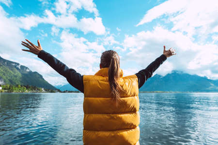 Young carefree woman traveler with open arms enjoying great view on Geneva lake in Switzerland.の写真素材