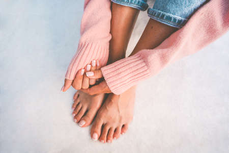 Stylish woman hands and feet with beautiful french manicure and pedicure on a white background with copy space. Manicure salon banner conceptの写真素材